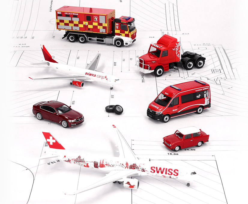 Auswahl aus der Herpa-Auslieferung Oktober 2026: Miniaturmodelle wie Flugzeuge, Einsatzfahrzeuge, Autos und eine Zugmaschine, alle in Rot und Weiß, auf einer technischen Zeichnung stehend.