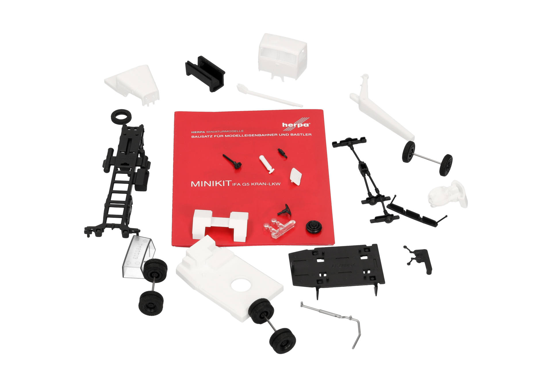 Modellbausatz, Schienenbauteile, Montagekit,  weißes Kunststoffteil, rote Anleitung, Modellbausatz, Lokomotivenbausatz, weiße Bauteile, schwarzer Rahmen, Montagekit