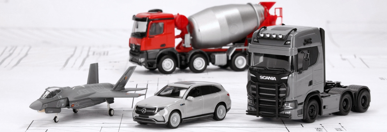 Link zu der Herpa Auslieferung von August 2025. Das Bild zeigt die Miniaturen von einer Lockheed Martin F-35A Lightning II im Maßstab 1:200, einen grauen Mercedes-Benz EQC AMG und einen Mercedes-Benz Arocs M Betonmischer-LKW,beide je im Maßstab 1:87